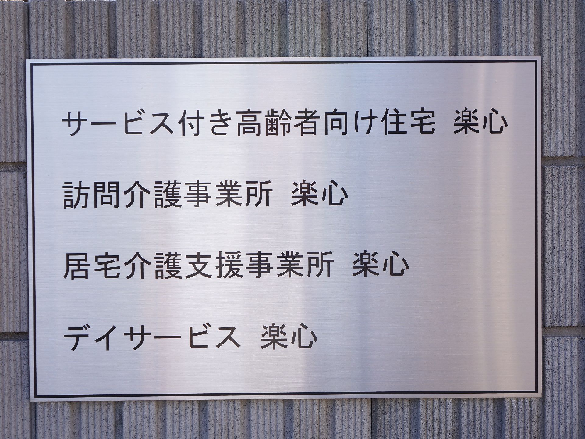 施設には事務所の設備内容を示すプレートが掲げられている。銀色のベースに黒の文字で、読みやすく分かりやすい内容である。