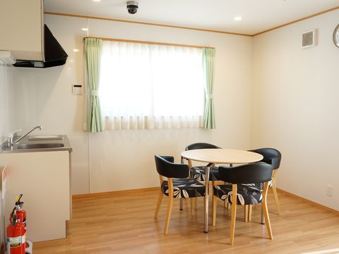 テーブルと椅子の配置された、消火器の用意されたキッチン