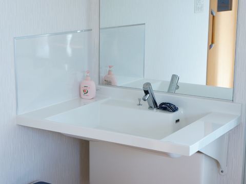 鏡がついている洗面台は、手をかざすと自動で水が出るので、使いやすい。ハンドソープが置かれているので自由に使える。