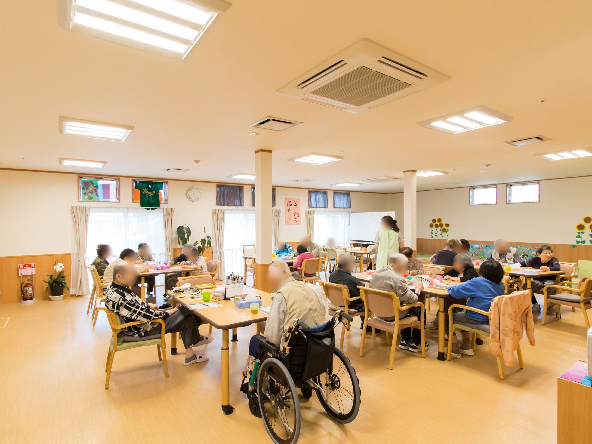 多目的ホールの様子である。利用者様が集まって、皆で工作を楽しんでいる。利用者様同士の交流を図る場所である。