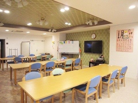 壁掛けの大型テレビを見ながら、食事やイベントを楽しむ共有スペース
