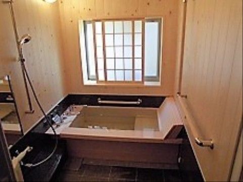 壁や浴槽、窓が木材でできている、温かみのあるお風呂場