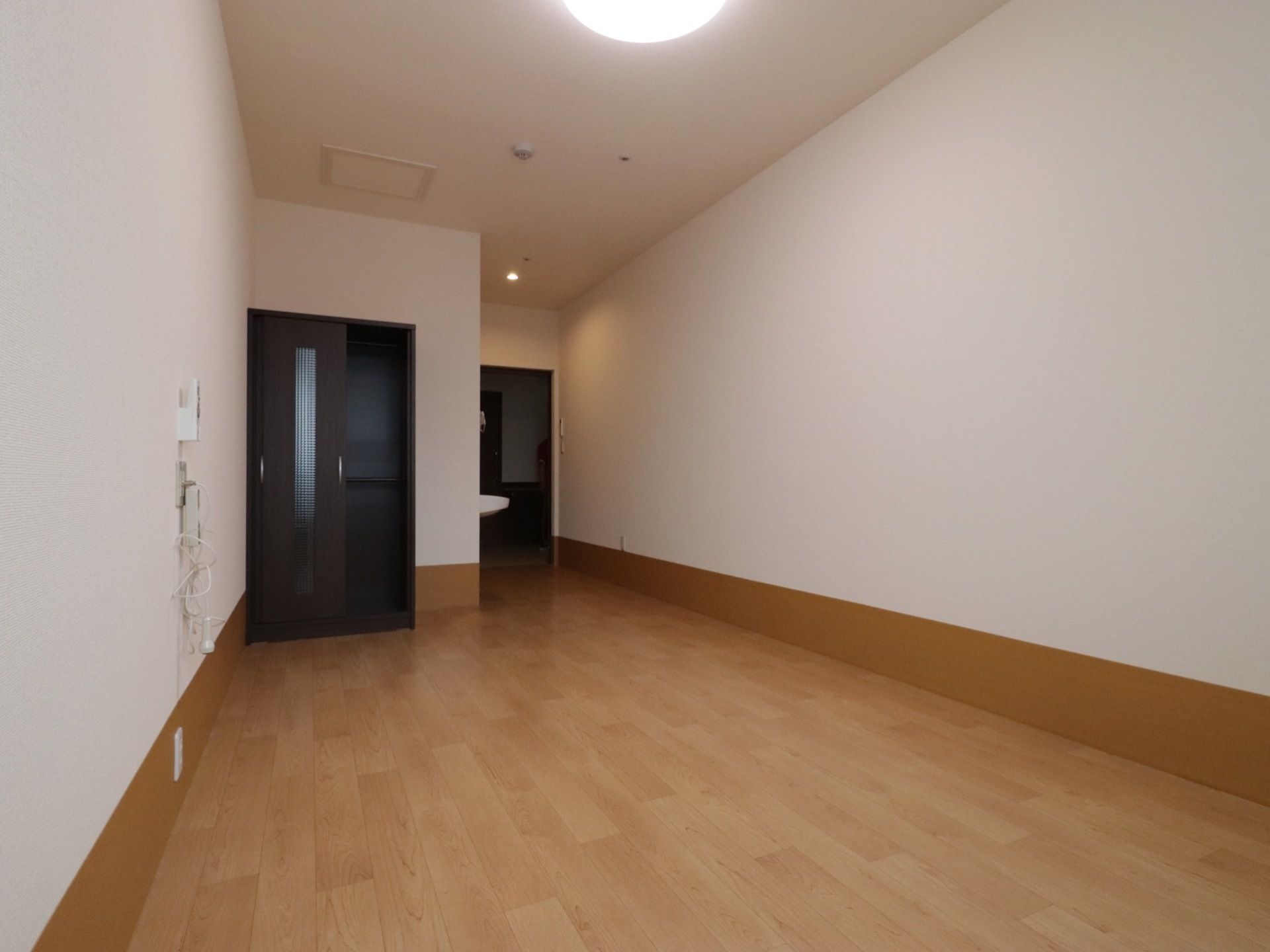 広い居室になっており、クローゼットが設置されている。白い壁になっており、清潔感のあるスペースになっている。