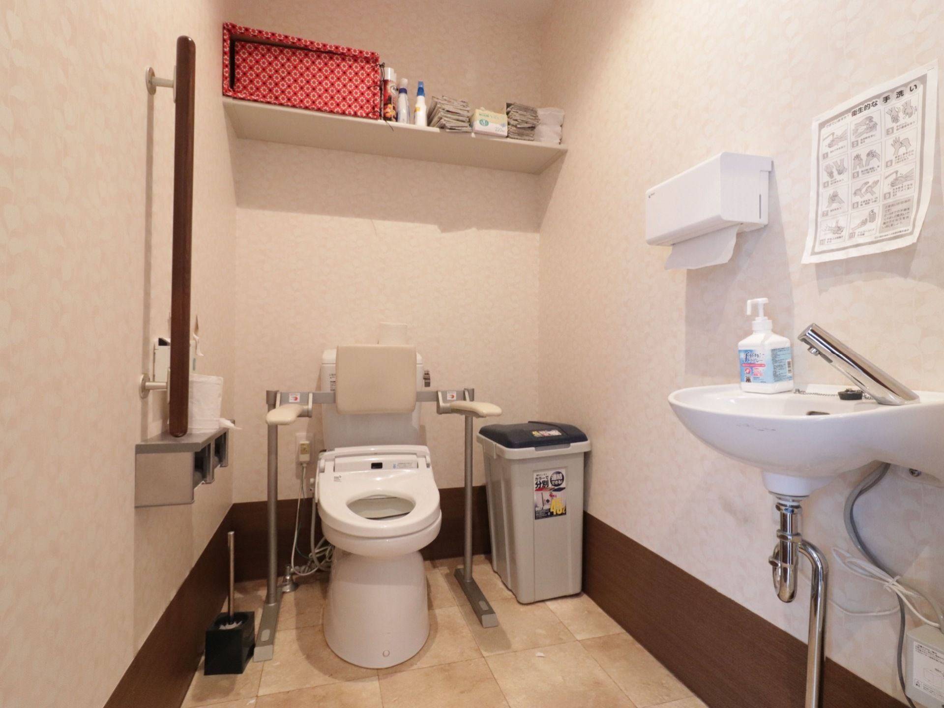 トイレは広々としていて、手すりも設置されている。右側には、簡易手洗い場や手拭き用のペーパーが完備されている。