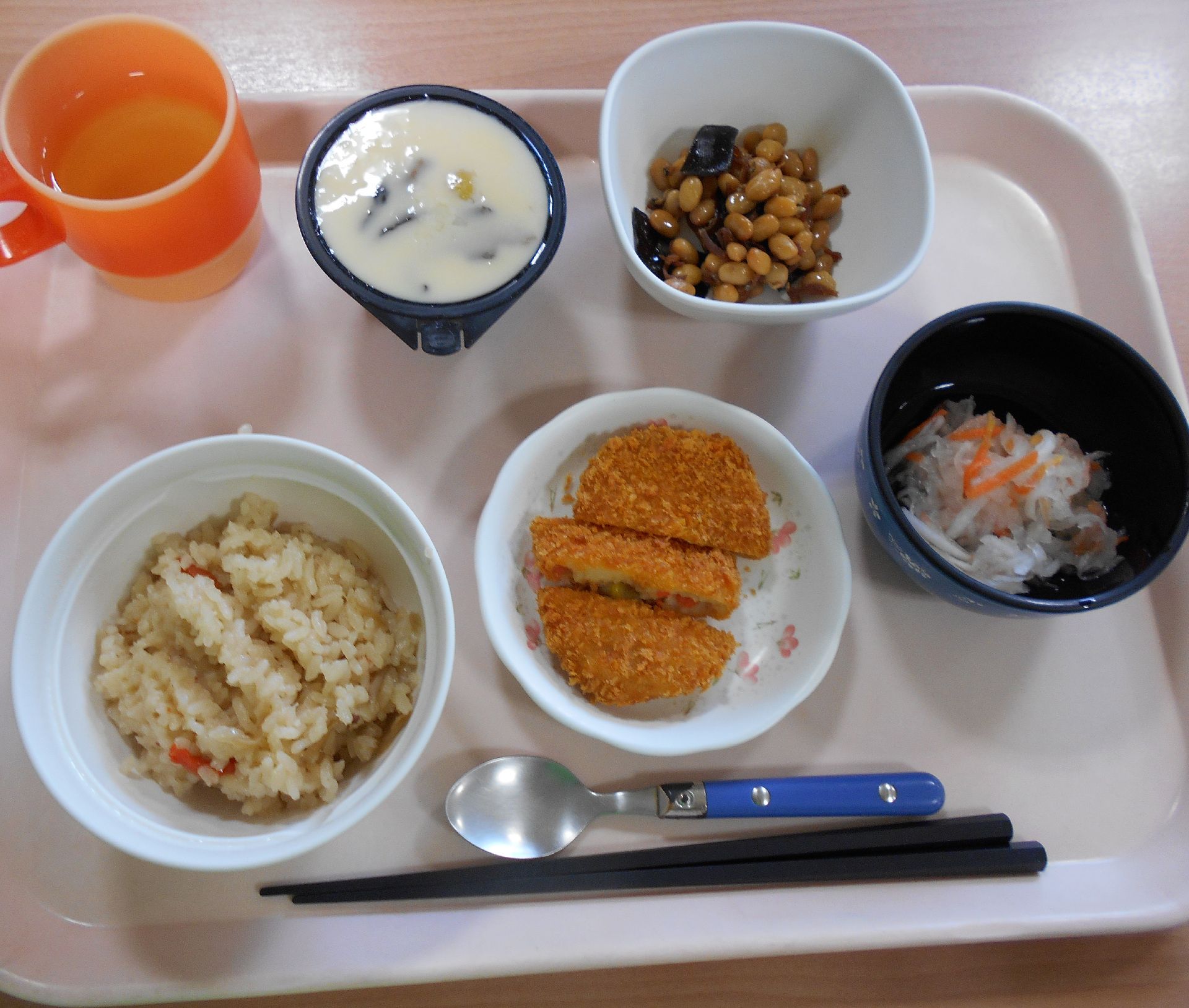 コロッケ、豆の煮物、酢の物に炊き込みご飯と茶碗蒸しがセットになった献立
