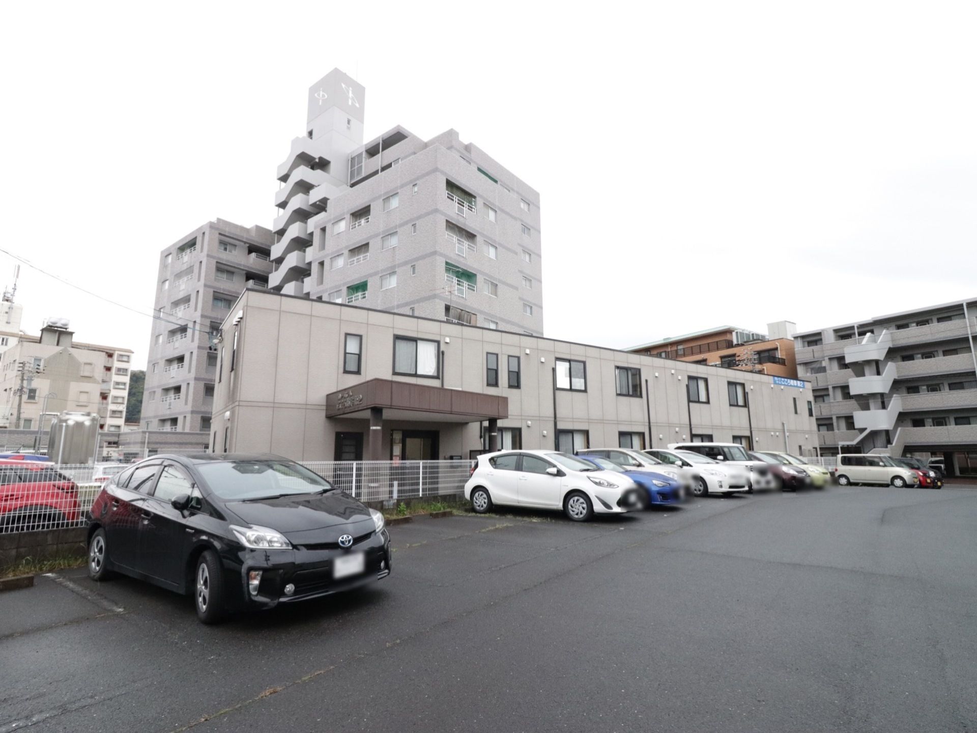 玄関の前の柵を挟んだところに、駐車場がある。車を一列に、横に15台以上停めることができる。後ろに車止めのブロックが設置してある。