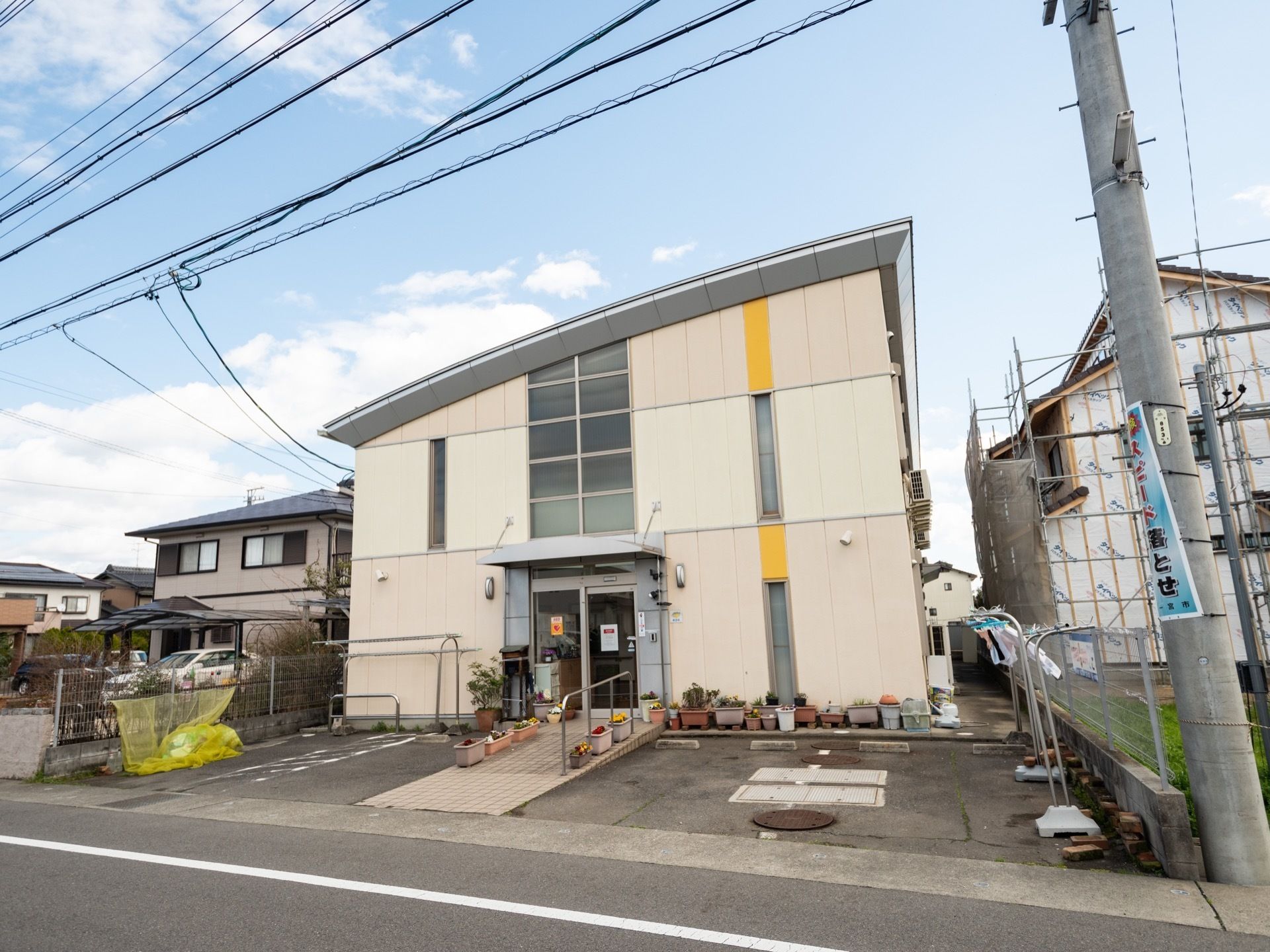 住宅街の中にある施設で、敷地内に駐車場が完備されている。ガラス張りの玄関の前には、スロープが設置されている。