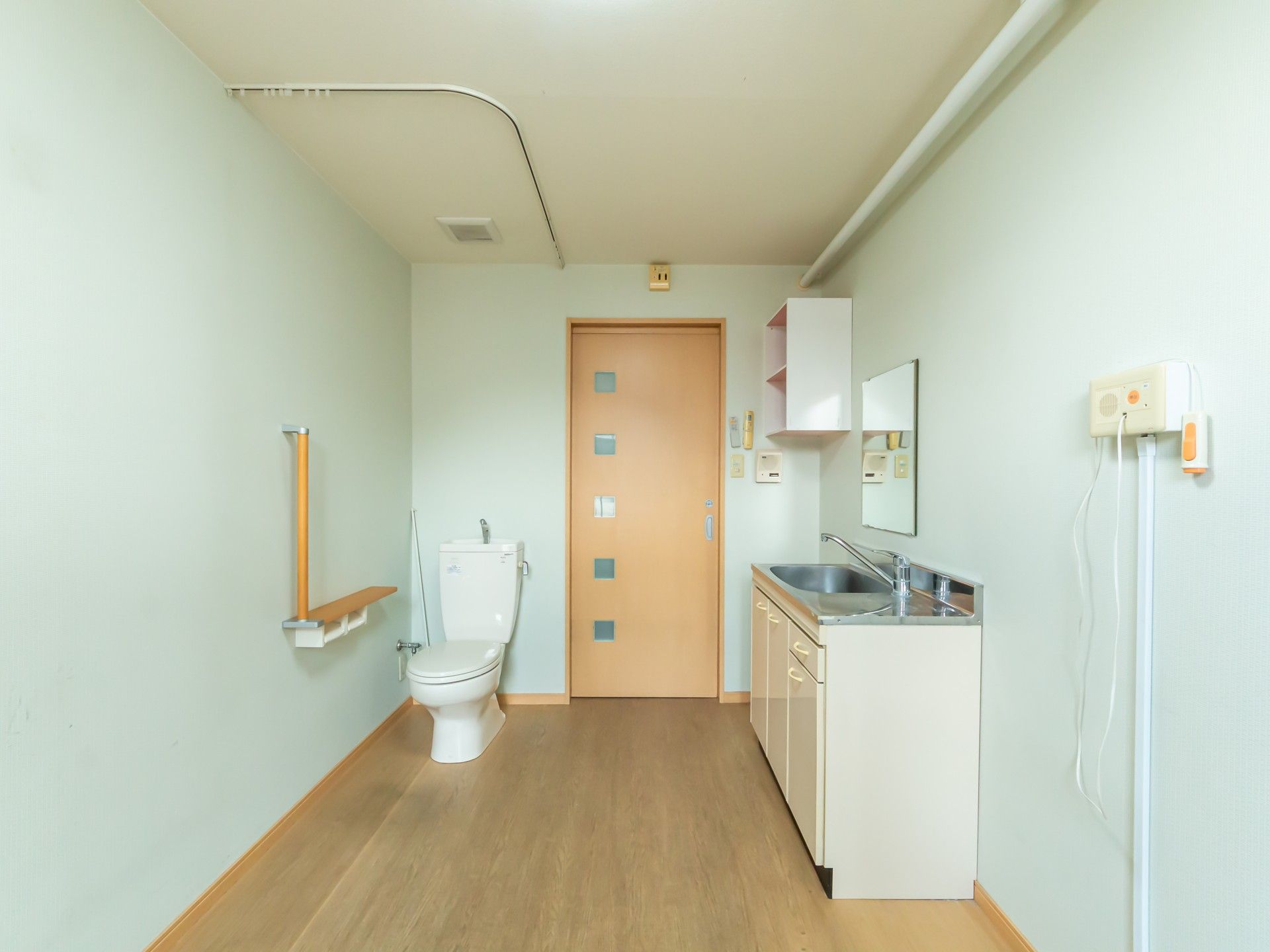 手すり付きのトイレと洗面台