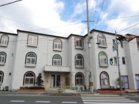 目の前に横断歩道のある、上部が丸型の窓が特徴的な外観