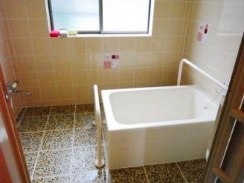 しっかりとした手すりが設置された浴室で、安全管理面も万全である。シンプルな白のバスタブで、衛生的である。