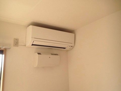 掃除がしやすい新しいタイプのエアコンが、天井近くに取り付けられている。エアコン下には空気清浄機も設置されている。