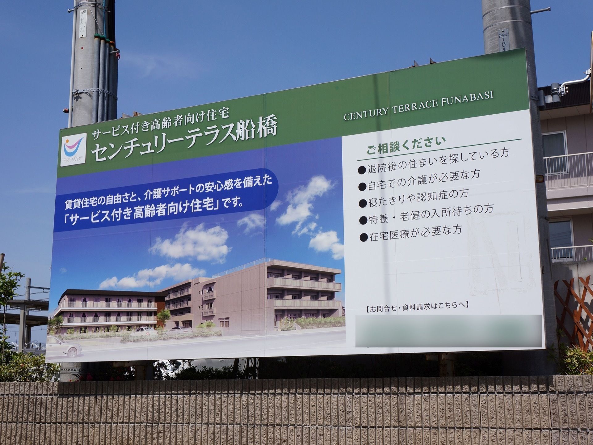 施設前の電柱に大型の看板を設置している。施設名とともに、資料請求の案内や簡単な施設概要を表示している。