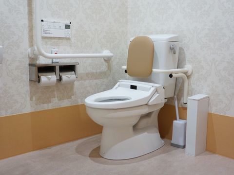 トイレには背もたれを設置し、壁に非常ボタンを配置している。操作パネルで動作する温水洗浄便座を採用している。