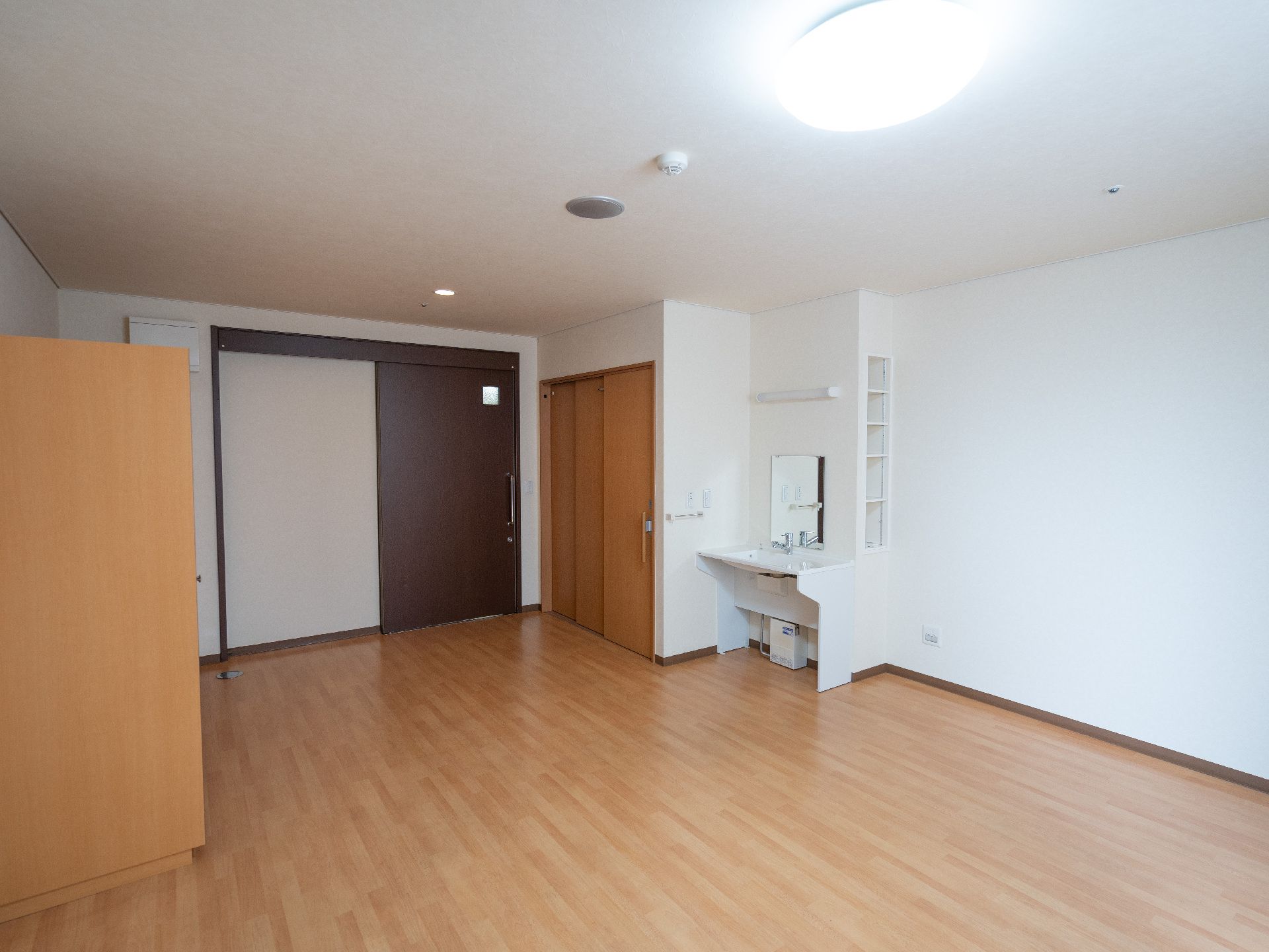 白い壁の部屋に置かれた足元が空いている洗面台