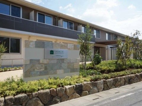 入り口には青々とした緑が多い、2階建ての施設の外観