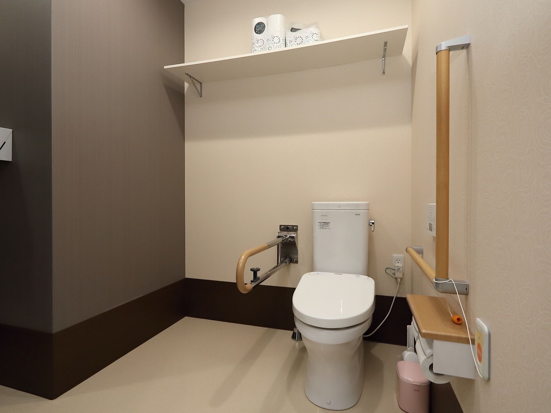 広めのスペースに暖房便座付きトイレがあり。周囲には手すりが取りつけられ、壁には呼び出しボタンも設置されている。