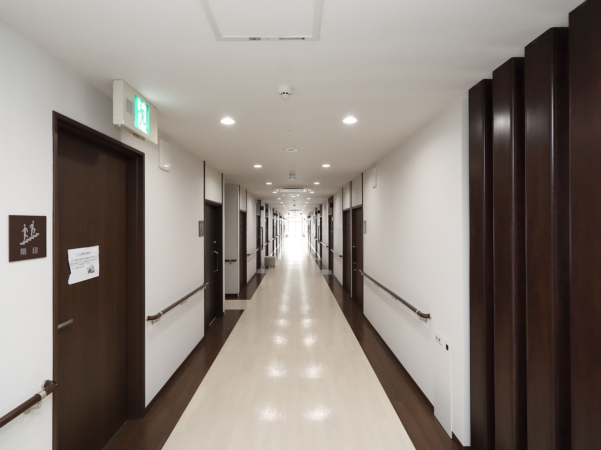 こげ茶色と白色の配色の内装で、通路の両側には手すりが取りつけられている。居室のドアは引き戸式になっている。