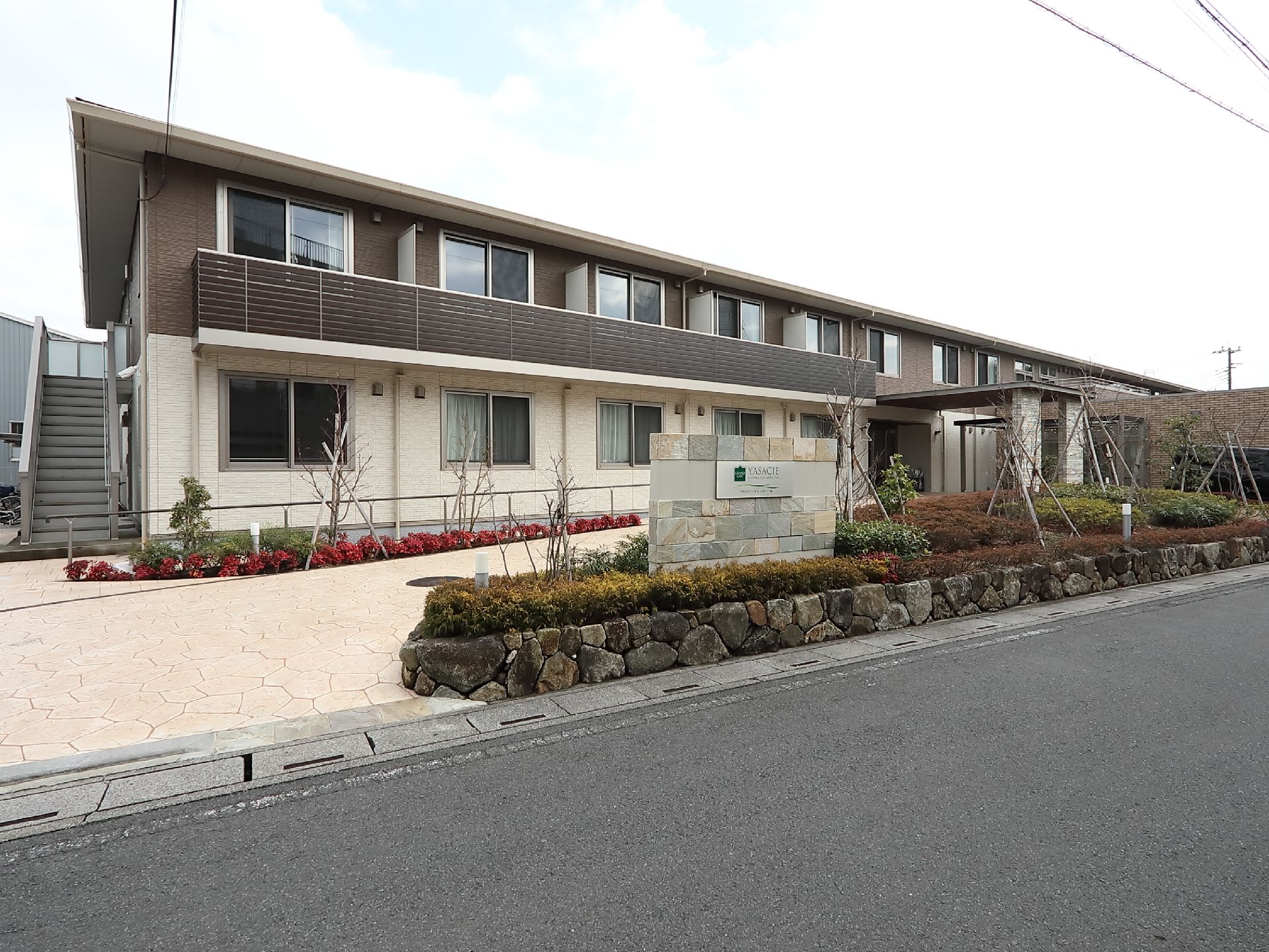 石造りの地面や看板が温かみを感じる、道路沿いに面する施設の外観