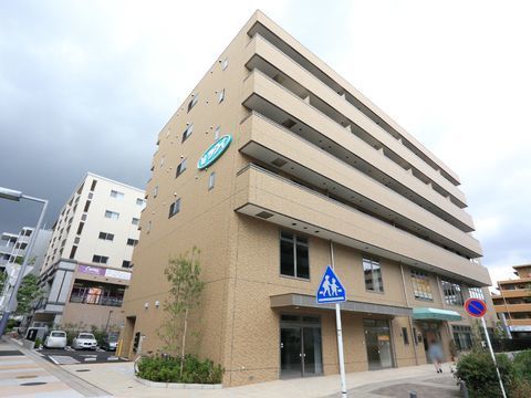 外観は茶色の壁にになっている。入り口の上には緑色の屋根があり、建物の横には木などの植物も植えられている。