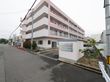 施設は４階建てで、薄いピンク色の外壁で統一されている。入口には、施設名の書かれたシルバーの表札が設置されている。