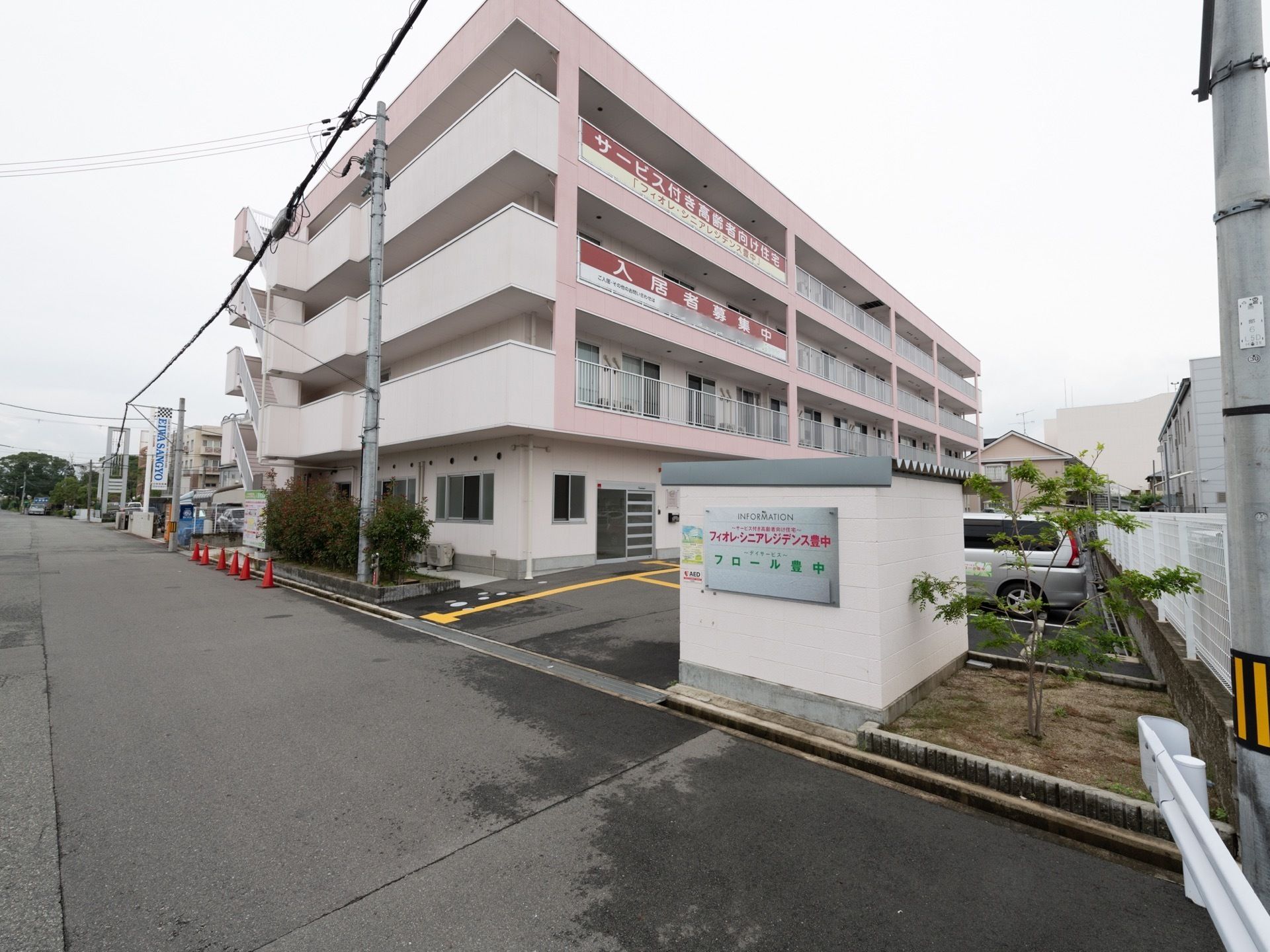 ピンク色の外壁が特徴の、遠くからでもわかる看板のある外観