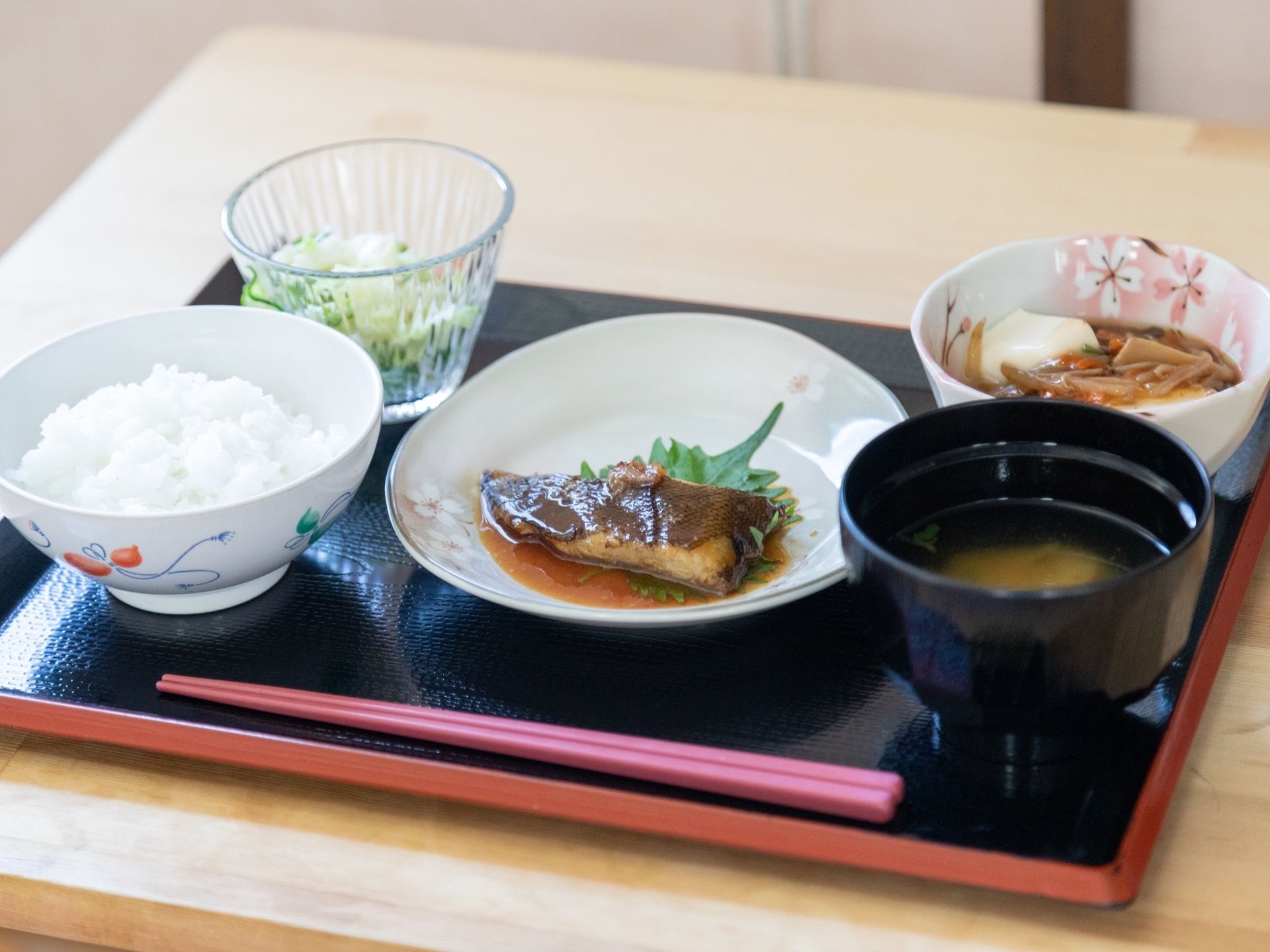 施設内で提供されている食事の一例である。今回は白米とみそ汁を中心とした和食となっており、中央の皿には主菜の煮魚が載っている。