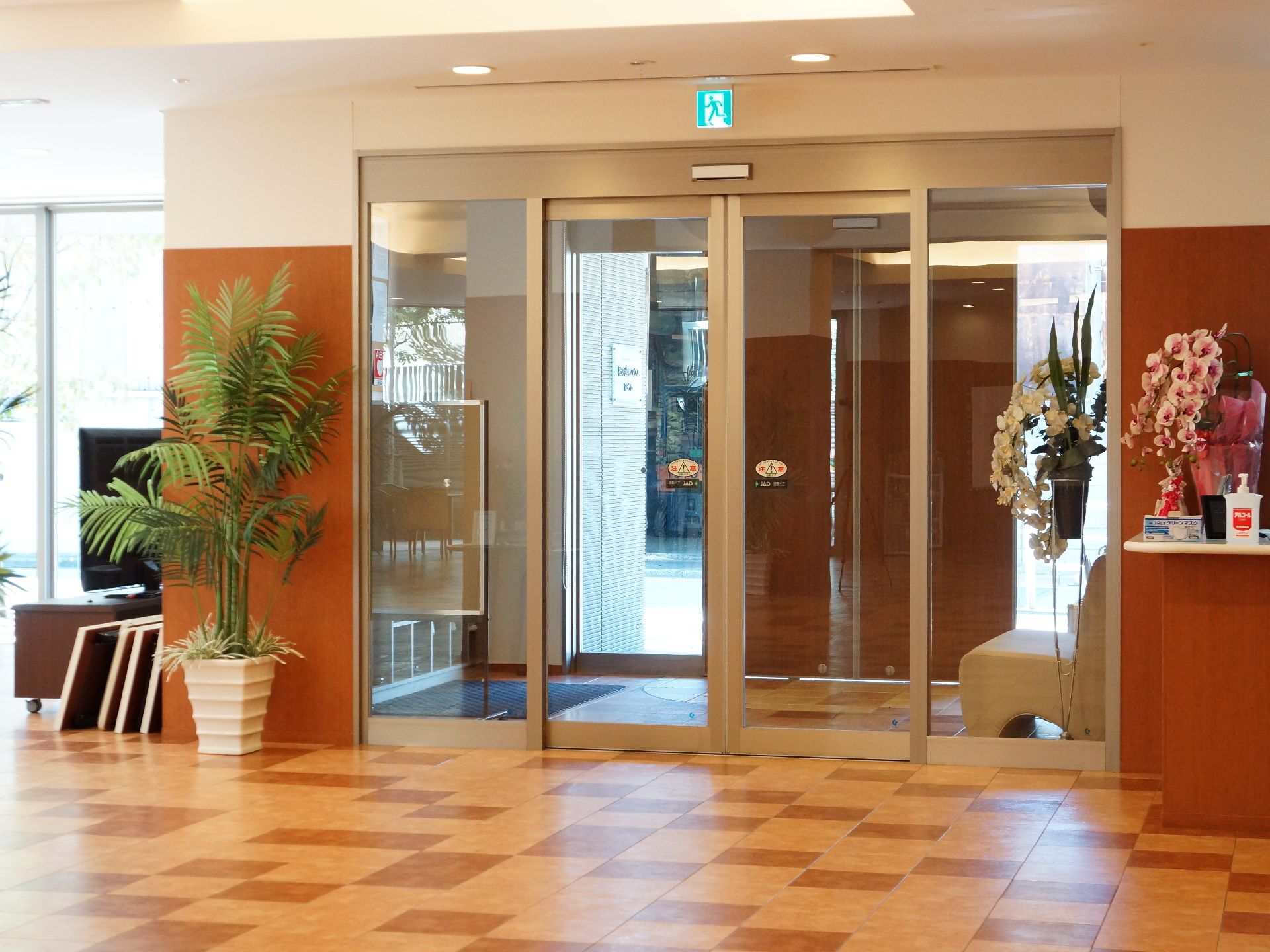 ホールには観葉植物が置かれている。入り口の隣に受付カウンターがある。カウンターの上には花等が飾られている。