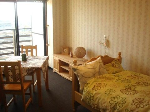 ２人掛けのダイニングテーブル、ベランダ付き手前にはベッドがある居住スペース
