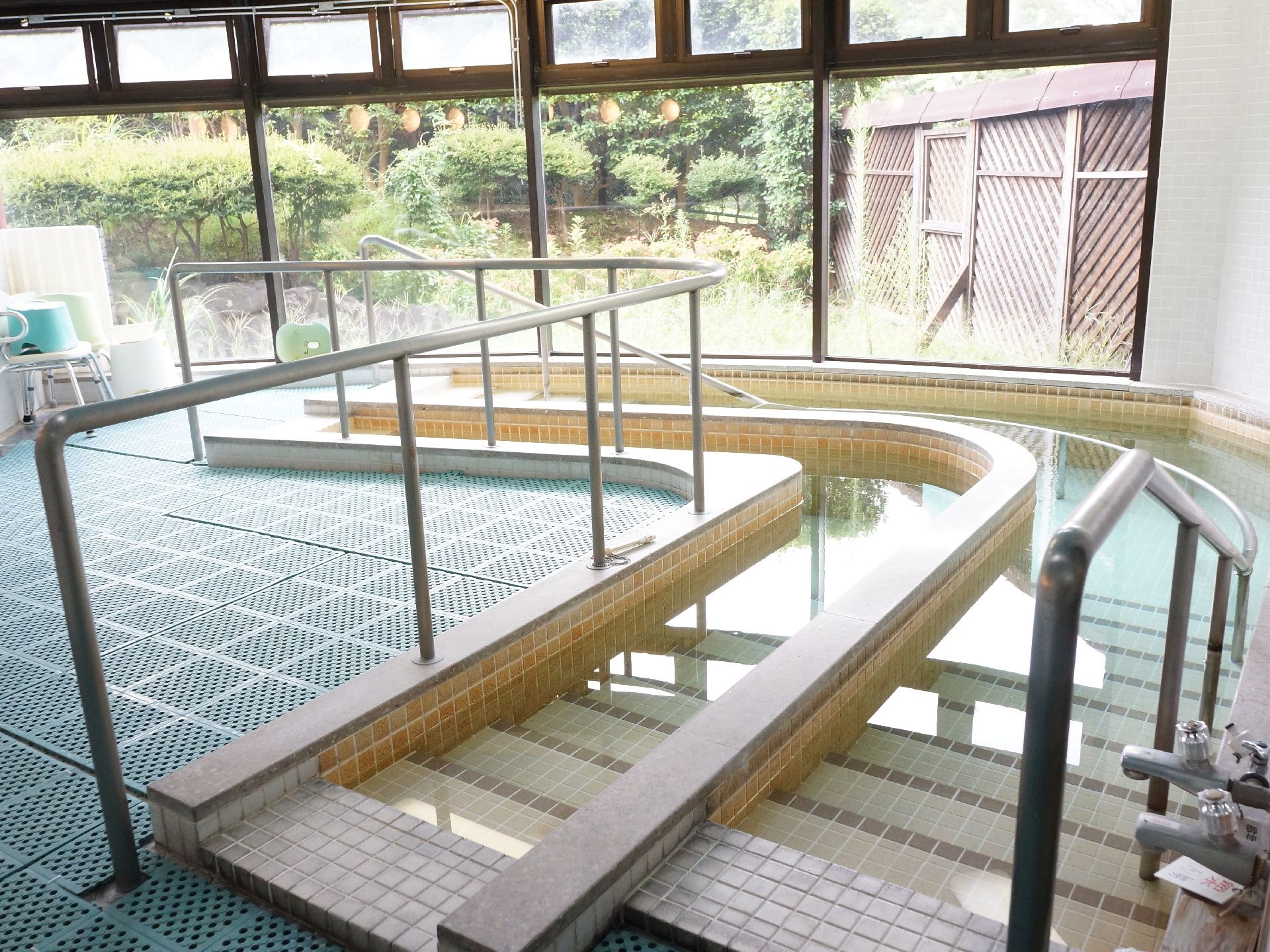 緩やかな階段で降りるタイプの浴槽が二列に並んでいる。大きな窓があり、広くて明るく、手すりも付いている。
