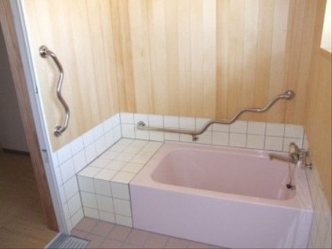 浴槽周辺の手すりは、角度が付けられ、つかみやすい構造である。木の壁は温もりを感じられ、リラックスした入浴時間を過ごすことができる。