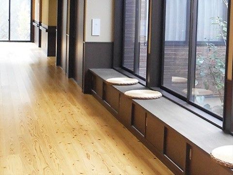 廊下からガラス越しに庭を眺めることができ、季節の花を楽しむことができる。腰かけるスペースも用意されてくつろぐことも可能。