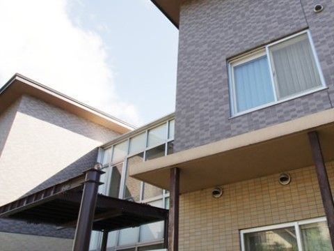 １階は黄土色、２階はグレーの濃淡が異なるタイルを張った外装である。ガラス張りの部分には黒いメタリックな屋根が付いている。