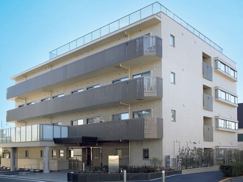 施設の建物は4階建てで、外壁にはベランダが設置されている。玄関にはベランダが設置され、フローリングがつながっている。