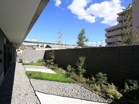 石や芝が並べられた、温かい雰囲気のある屋内から眺められる庭