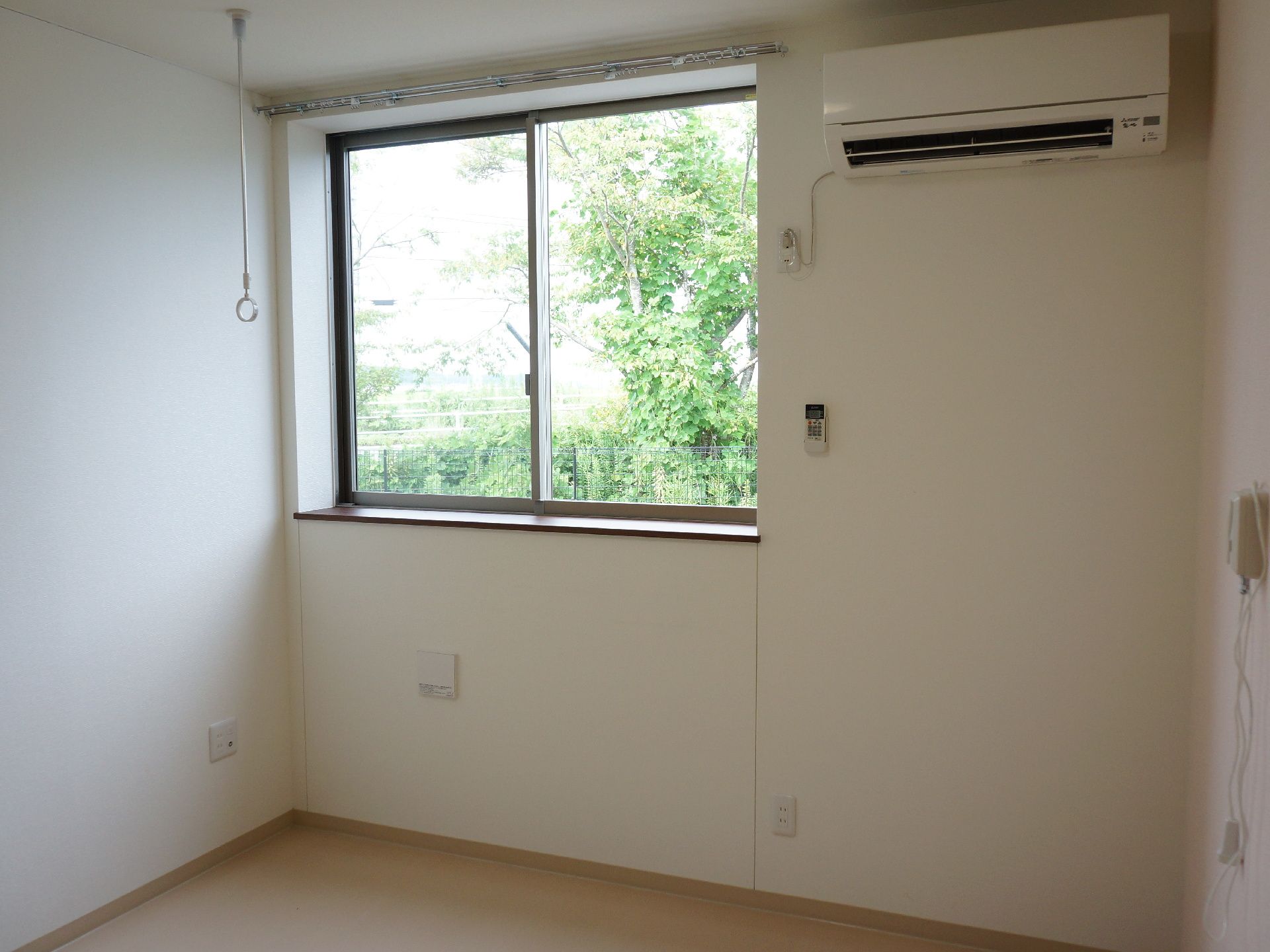 部屋の窓からは、緑の木が良く見える。部屋の壁にはコンセントが多く取り付けられているので、電化製品を使用することができる。