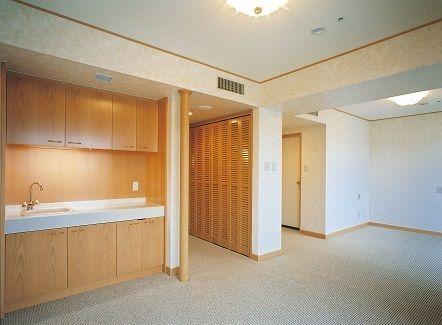 簡易キッチンのシンクには高齢者が扱いやすいように、レバー式の蛇口を設置している。また壁には緊急時の呼び出しボタンを備え付けている。