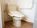 温水洗浄便座がある。トイレは清掃が行き届いており、清潔感がある。壁面には手すりが取り付けられている。