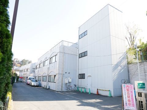 施設の敷地は奥行きがある。門を入ると白い２階建ての建物があり、屋上もある。建物の横には車を停めるスペースがある。