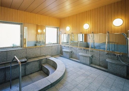石の床や浴槽、壁の大浴場は、入居者様の共有スペースの一つである。横一列に鏡が張ってあり、周りが良く見える。