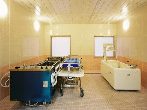 窓のある部屋で、機械を用いて入浴する。横になることができるストレッチャー型の器具や特殊な浴槽がある。