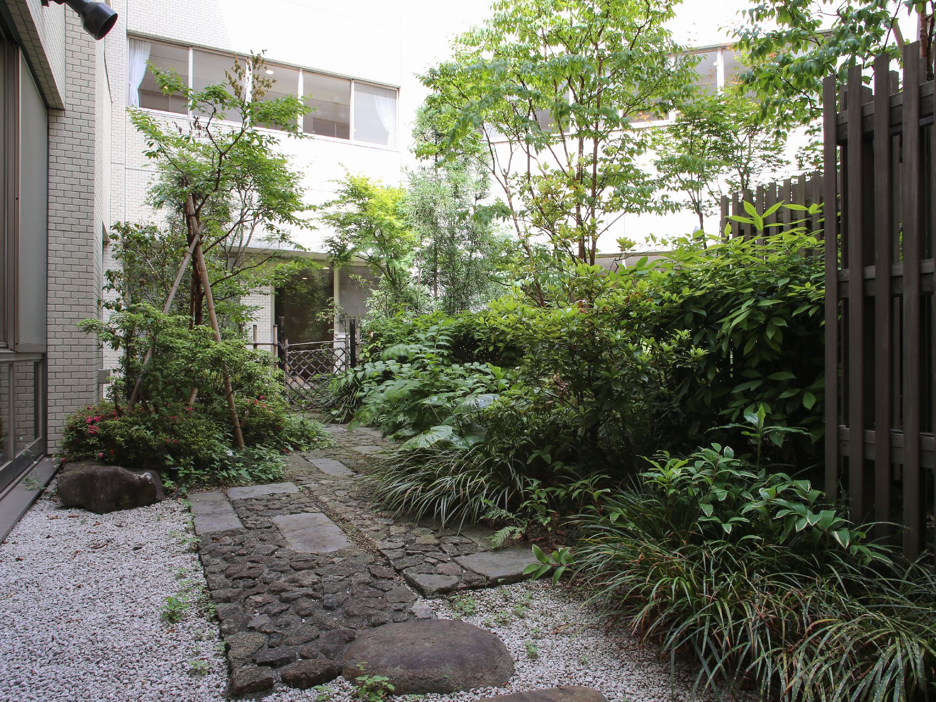 日本庭園が広がっている。たくさんの種類の木や花などの植物が植えられている。敷石もあり、散歩もできる。