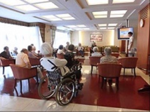 ご入居者様がお話を聞く中、健康維持について説明する看護師