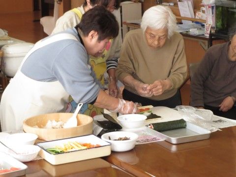 節分の日に、スタッフの力を借りながら恵方巻づくりに挑戦するご入居者様