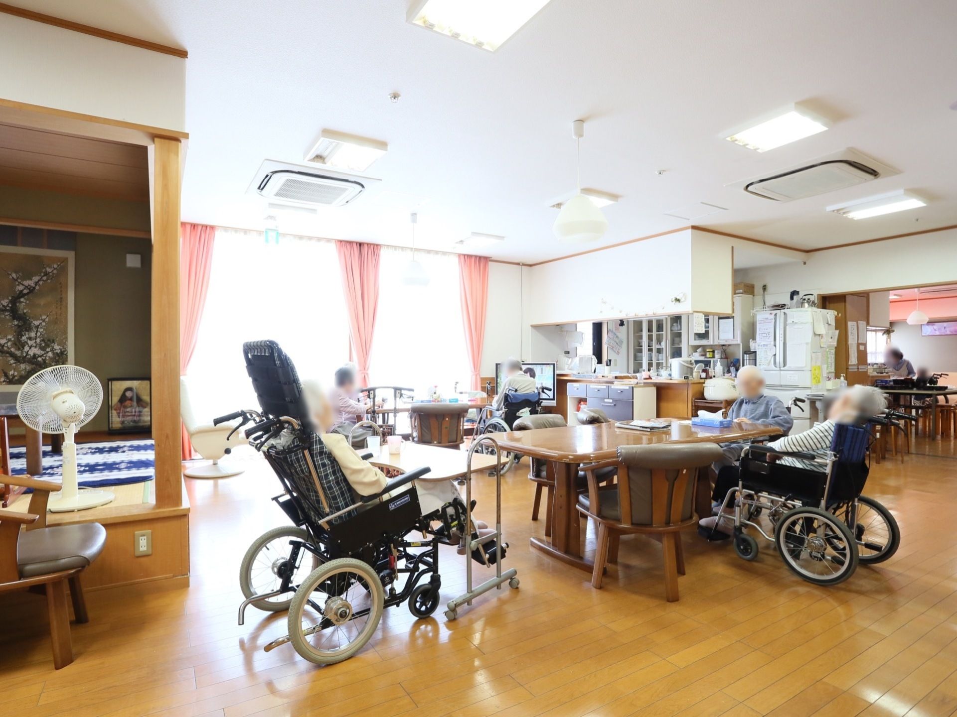 大きなテーブル、テレビ、小上がりの座敷がある。日中は大きな窓から光が差し込み部屋は自然の明かりで満たされる。空調も完備されている。