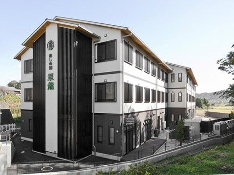 黒と白のモダンな雰囲気が特徴的な、3階建ての施設の外観