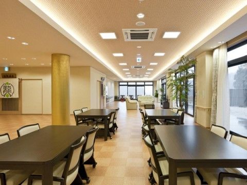 リビングには木製のテーブルが並んでいる。食事以外にも、入居者様の憩いのスペースとして利用することができる。
