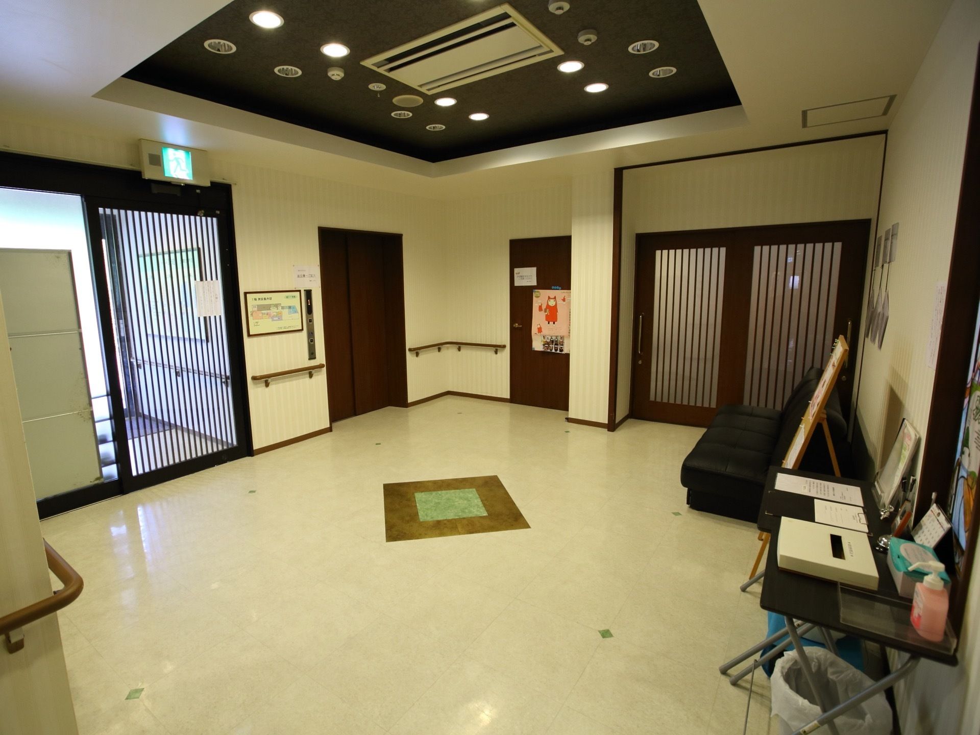 エントランスホールは明るく広々とした空間になっている。エレベーターが設置されており、壁際にソファが置かれている。