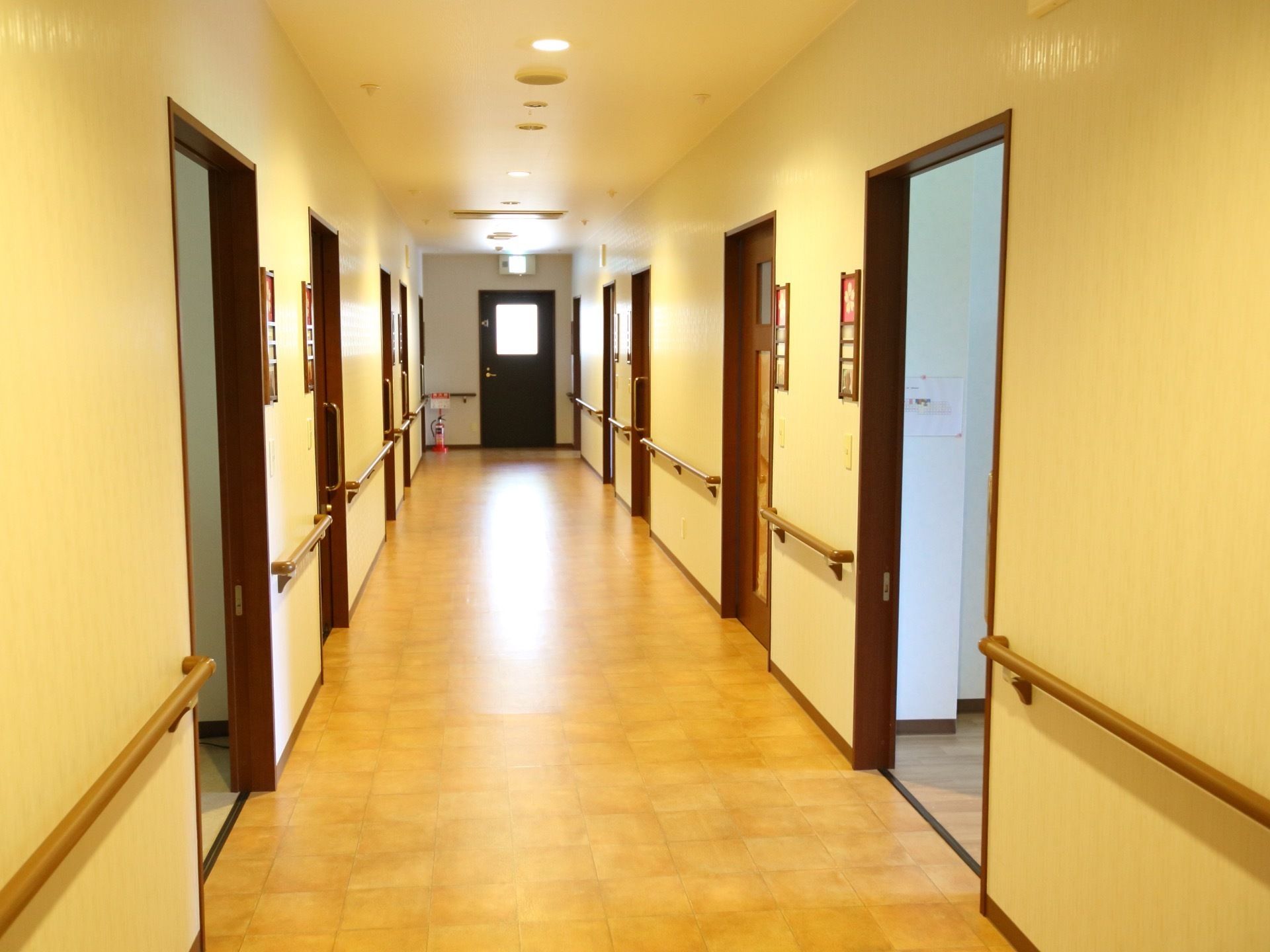 幅が広く温かい雰囲気の廊下である。左右に居室が設けられており、壁に手すりがある。突き当りに非常用扉がある。