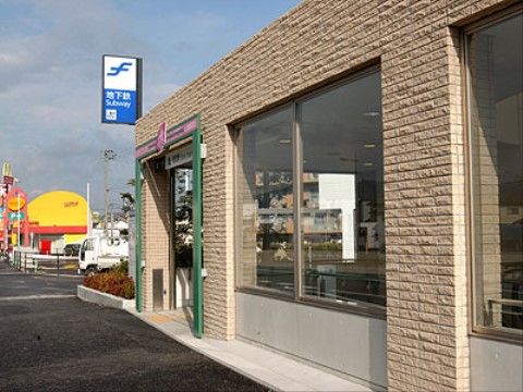 入口は淡いブラウンの建物である。屋根より高い突き出た位置に、地下鉄の駅があることを示す表示が掲げられている。