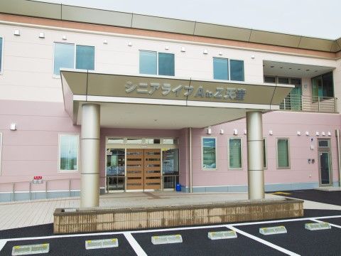 駐車場の玄関前には屋根があり、屋根の下に車をつけることができる設計である。屋根には銀色の文字で施設名が記してある。